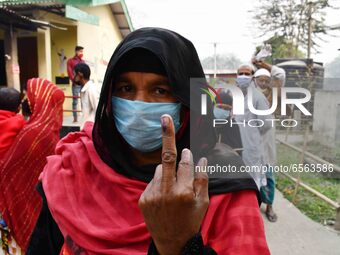 Woman voters hold up inked fingers after casting ballot  in the first  phase of polling for Assam Assembly Elections, at  Rupohi   constitue...