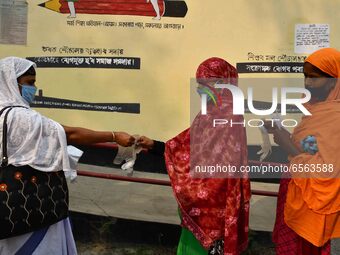 Voters put on gloves as part of precautions against COVID-19 while waiting to cas votes at a polling station, during the first phase of poll...