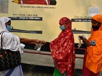 Voters put on gloves as part of precautions against COVID-19 while waiting to cas votes at a polling station, during the first phase of poll...