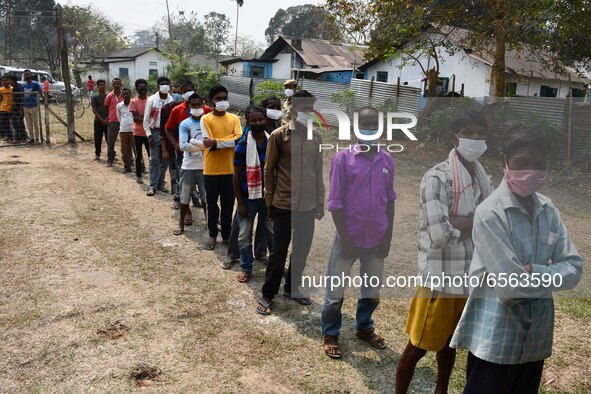 oters wait in queue to cast their ballots at a polling station during Phase 1 of Assam's legislative election in Nagaon district, in the nor...