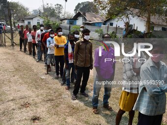 oters wait in queue to cast their ballots at a polling station during Phase 1 of Assam's legislative election in Nagaon district, in the nor...