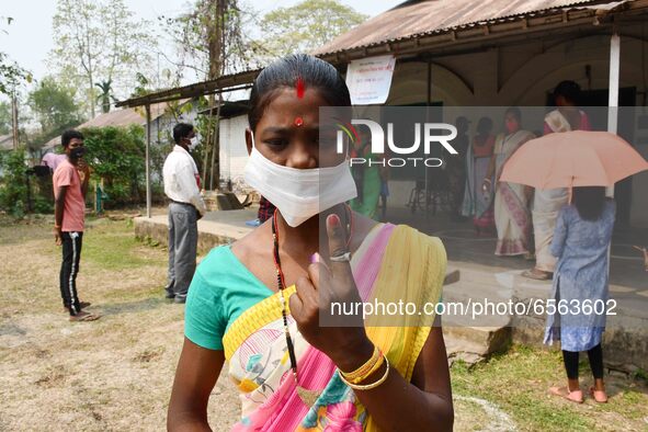 Woman voters hold up inked fingers after casting ballot  in the first  phase of polling for Assam Assembly Elections, at  Rupohi   constitue...