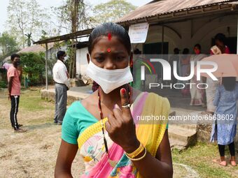 Woman voters hold up inked fingers after casting ballot  in the first  phase of polling for Assam Assembly Elections, at  Rupohi   constitue...