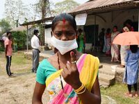 Woman voters hold up inked fingers after casting ballot  in the first  phase of polling for Assam Assembly Elections, at  Rupohi   constitue...