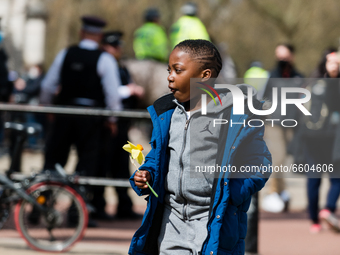 Boy lays down a bouquet of flowers outside Buckingham Palace after it was announced that Britain's Prince Philip, husband of Queen Elizabeth...