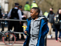 Boy lays down a bouquet of flowers outside Buckingham Palace after it was announced that Britain's Prince Philip, husband of Queen Elizabeth...