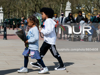 Girl and a boy lays down a bouquet of flowers outside Buckingham Palace after it was announced that Britain's Prince Philip, husband of Quee...