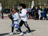 Girl and a boy lays down a bouquet of flowers outside Buckingham Palace after it was announced that Britain's Prince Philip, husband of Quee...