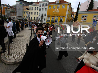 Students wearing protective masks and holding placards alluding to the university crisis march through the different streets of Lisbon. Apri...