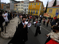 Students wearing protective masks and holding placards alluding to the university crisis march through the different streets of Lisbon. Apri...