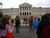 Students wearing protective masks and holding placards alluding to the university crisis march through the different streets of Lisbon. Apri...