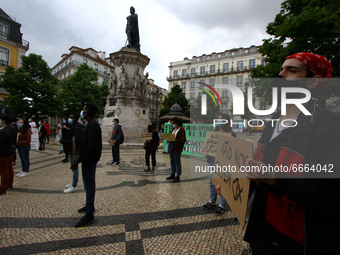 Students wearing protective masks and holding signs alluding to the university crisis march through the different streets of Lisbon. April 2...