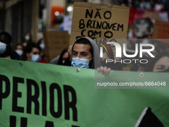 Students wearing protective masks and holding placards alluding to the university crisis march through the different streets of Lisbon. Apri...