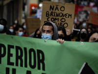 Students wearing protective masks and holding placards alluding to the university crisis march through the different streets of Lisbon. Apri...