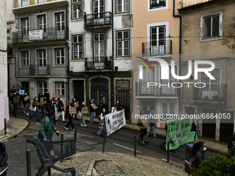 Students wearing protective masks and holding placards alluding to the university crisis march through the different streets of Lisbon. Apri...