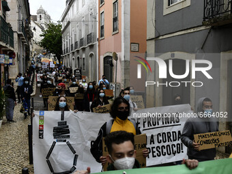 Students wearing protective masks and holding placards alluding to the university crisis march through the different streets of Lisbon. Apri...