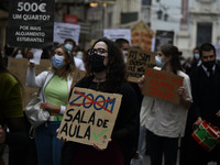 Students wearing protective masks and holding placards alluding to the university crisis march through the different streets of Lisbon. Apri...