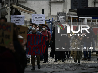 Students wearing protective masks and holding placards alluding to the university crisis march through the different streets of Lisbon. Apri...