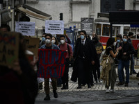 Students wearing protective masks and holding placards alluding to the university crisis march through the different streets of Lisbon. Apri...