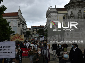 Students wearing protective masks and holding placards alluding to the university crisis march through the different streets of Lisbon. Apri...