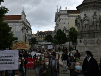 Students wearing protective masks and holding placards alluding to the university crisis march through the different streets of Lisbon. Apri...