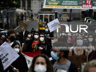 Students wearing protective masks and holding placards alluding to the university crisis march through the different streets of Lisbon. Apri...