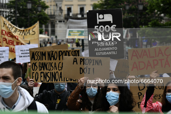 Students wearing protective masks and holding placards alluding to the university crisis march through the different streets of Lisbon. Apri...