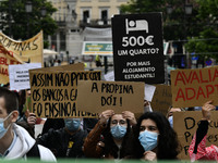 Students wearing protective masks and holding placards alluding to the university crisis march through the different streets of Lisbon. Apri...