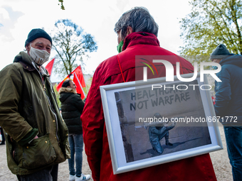 A woman is carrying a placard on her back, in support of the healthcare system, during the International Worker's Day demonstration held in...