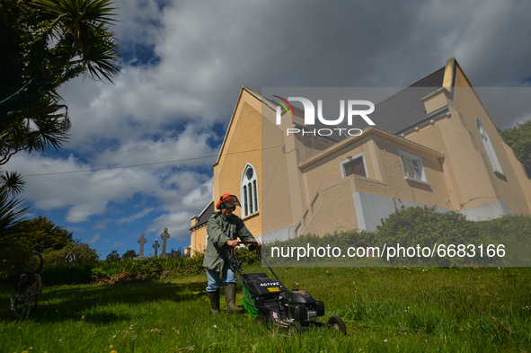 Father Krzysztof Sikora cuts the grass around the 'Our Lady Star Of The Sea' Roman Catholic church in Roundstone, Connemara.

Geographically...