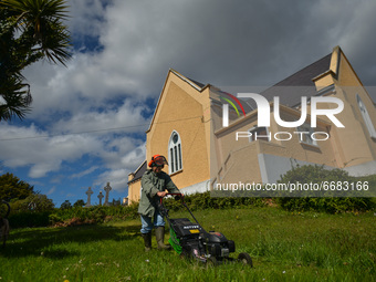 Father Krzysztof Sikora cuts the grass around the 'Our Lady Star Of The Sea' Roman Catholic church in Roundstone, Connemara.

Geographically...