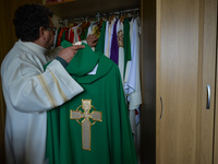 Father Krzysztof Sikora inspects the chasuble in the sacristy of the Roman Catholic Church 'Our Lady Star Of The Sea' in Roundstone, Connema...