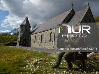 Father Krzysztof Sikora checks his mobile phone outside St James's Church, in Cashel, Connemara.

Geographically, Roundstone parish is consi...