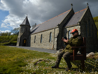 Father Krzysztof Sikora checks his mobile phone outside St James's Church, in Cashel, Connemara.

Geographically, Roundstone parish is consi...