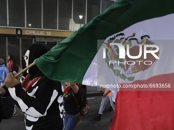 A person dressed as a skull carries a Mexican flag while demonstrating on Avenida Tláhuac after the collapse of Metro line 12 on the night o...