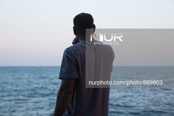 A migrant waits near the sea, in the city of Ventimiglia at the French-Italian border, on June 23, 2015. The situation of migrants camped in...