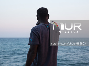 A migrant waits near the sea, in the city of Ventimiglia at the French-Italian border, on June 23, 2015. The situation of migrants camped in...