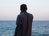 A migrant waits near the sea, in the city of Ventimiglia at the French-Italian border, on June 23, 2015. The situation of migrants camped in...