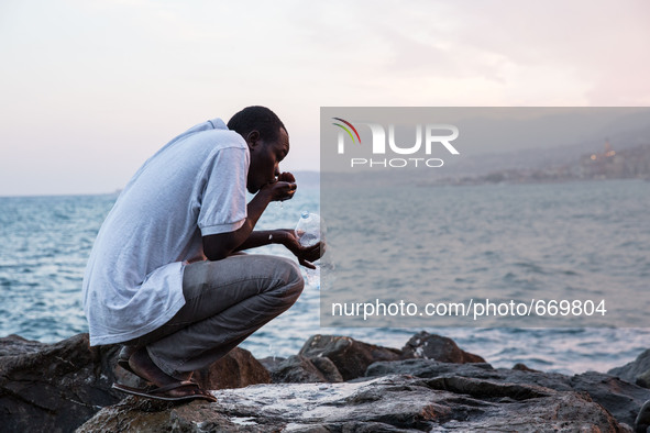 A migrant waits near the sea, in the city of Ventimiglia at the French-Italian border, on June 23, 2015. The situation of migrants camped in...