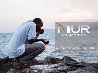 A migrant waits near the sea, in the city of Ventimiglia at the French-Italian border, on June 23, 2015. The situation of migrants camped in...