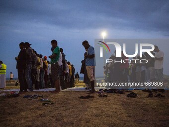 Migrants pray near the sea in the city of Ventimiglia on the French-Italian border, on June 23, 2015. The situation of migrants camped in Ve...