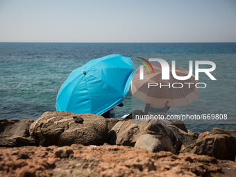 Mingrants waits near the sea, in the city of Ventimiglia at the French-Italian border, on June 24, 2015. The situation of migrants camped in...