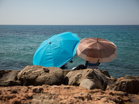 Mingrants waits near the sea, in the city of Ventimiglia at the French-Italian border, on June 24, 2015. The situation of migrants camped in...