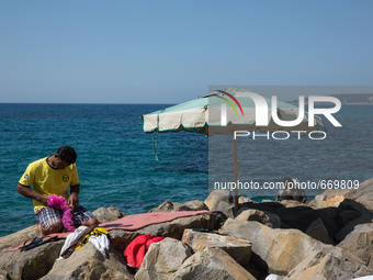 Migrants wait near the sea, in the city of Ventimiglia at the French-Italian border, on June 24, 2015. The situation of migrants camped in V...