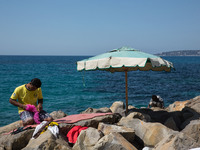 Migrants wait near the sea, in the city of Ventimiglia at the French-Italian border, on June 24, 2015. The situation of migrants camped in V...