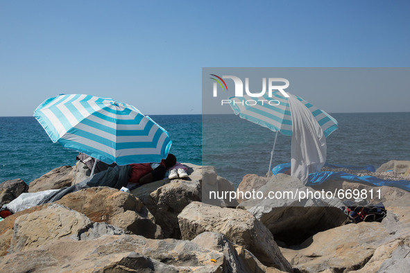 Migrants wait near the sea, in the city of Ventimiglia at the French-Italian border, on June 24, 2015. The situation of migrants camped in V...