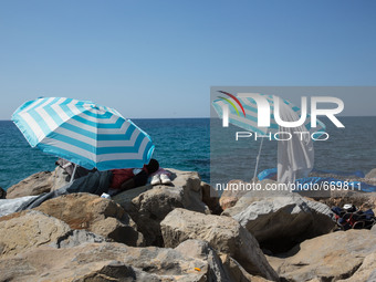 Migrants wait near the sea, in the city of Ventimiglia at the French-Italian border, on June 24, 2015. The situation of migrants camped in V...