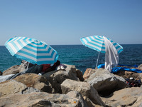 Migrants wait near the sea, in the city of Ventimiglia at the French-Italian border, on June 24, 2015. The situation of migrants camped in V...