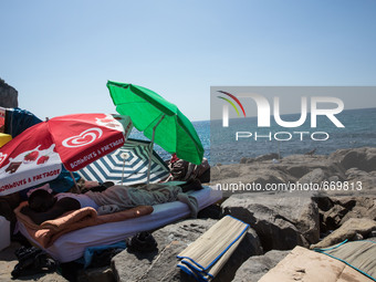 A migrant sleep near the sea, in the city of Ventimiglia at the French-Italian border, on June 24, 2015. The situation of migrants camped in...