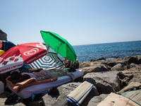 A migrant sleep near the sea, in the city of Ventimiglia at the French-Italian border, on June 24, 2015. The situation of migrants camped in...